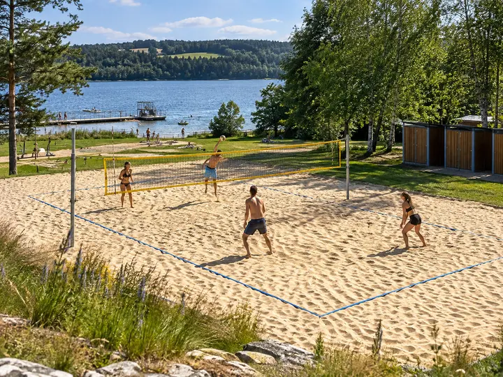 Venkovní beachvolejbalový kurt se čtyřmi hráči při pohledu shora.